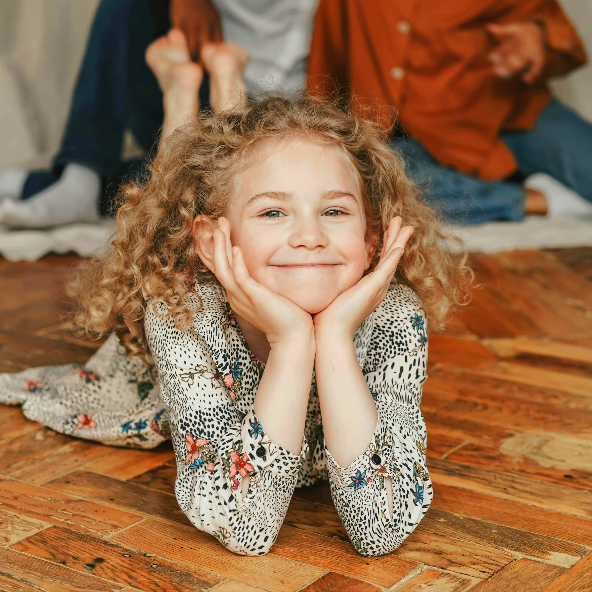 child is happy with elbows supporting chin on floor