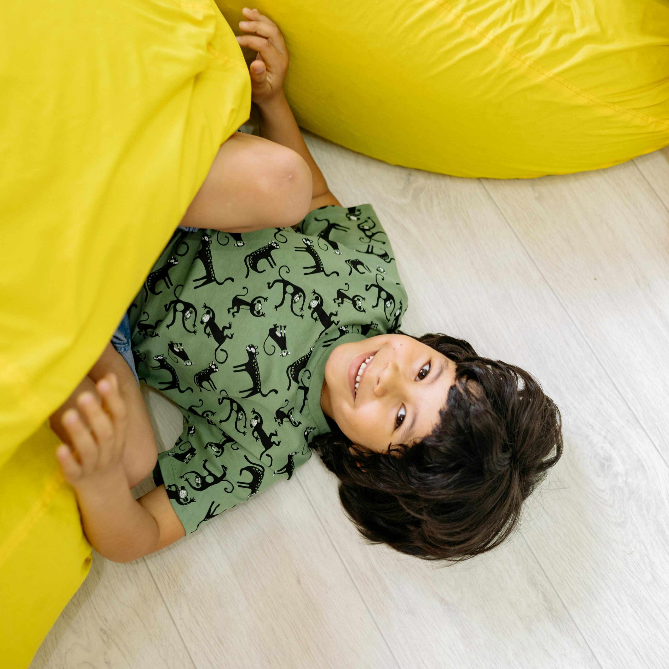 child plays under bean bag